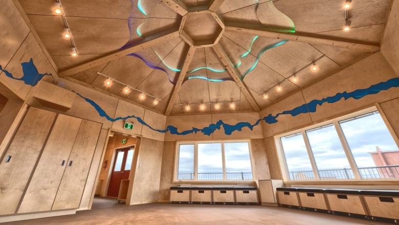 inside a wood-paneled round room with high ceilings and large windows