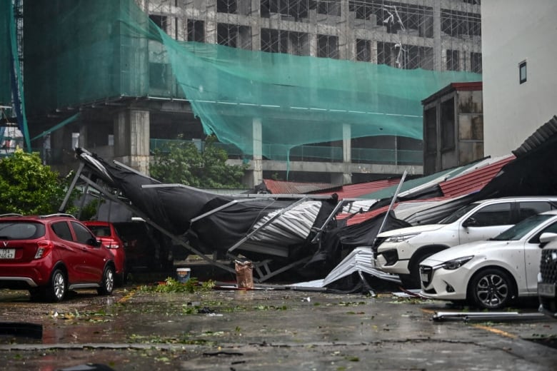 Cars are covered in debris in a parking lot. 