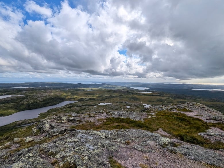 A rocky landscape is contrasted with a cloudy sky.