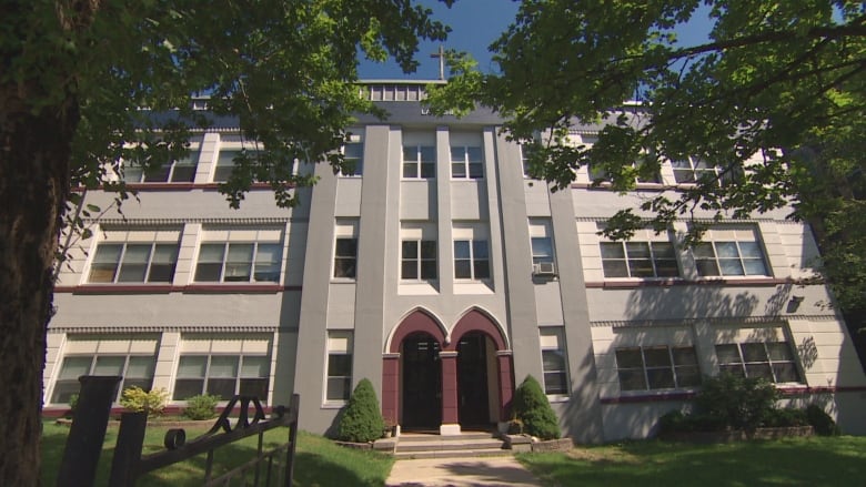 Grey school with arched burgundy doorways.