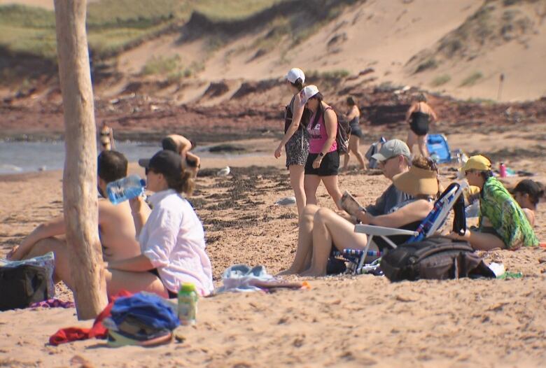 People on Cavendish Beach with dunes in the background.