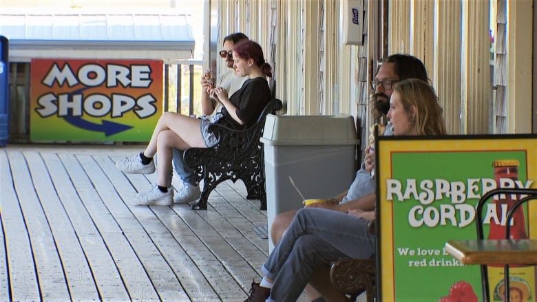 People sitting on Cavendish boardwalk eating ice cream.