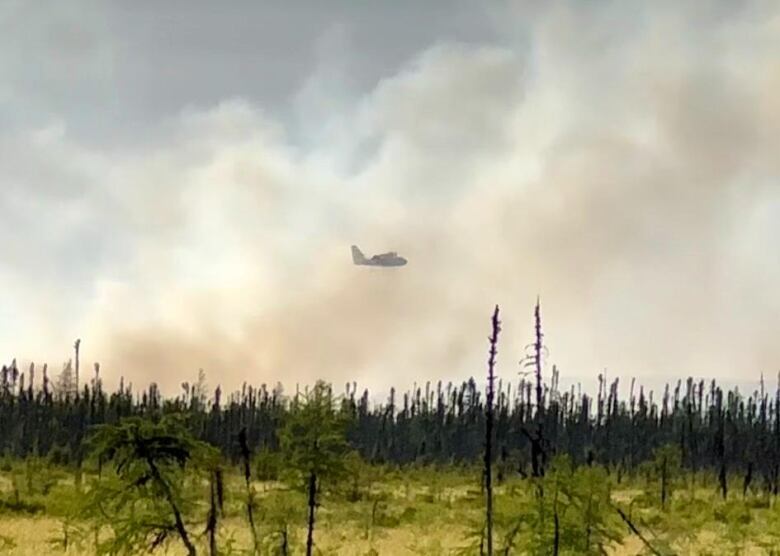 a waterbomber in the middle of thick smoke that emerged from a nearby wildfire close to town in Happy Valley- Goose Bay.