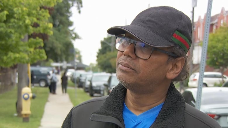 Man in a baseball hat outside a school