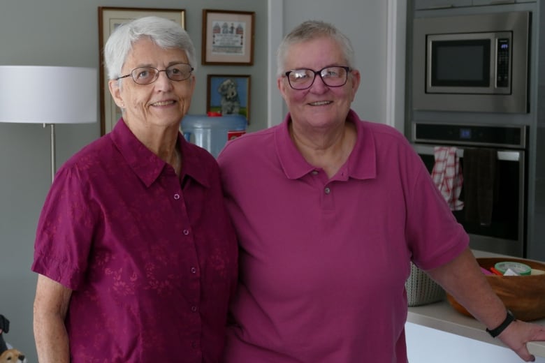 Two women stand side by side looking at the camera