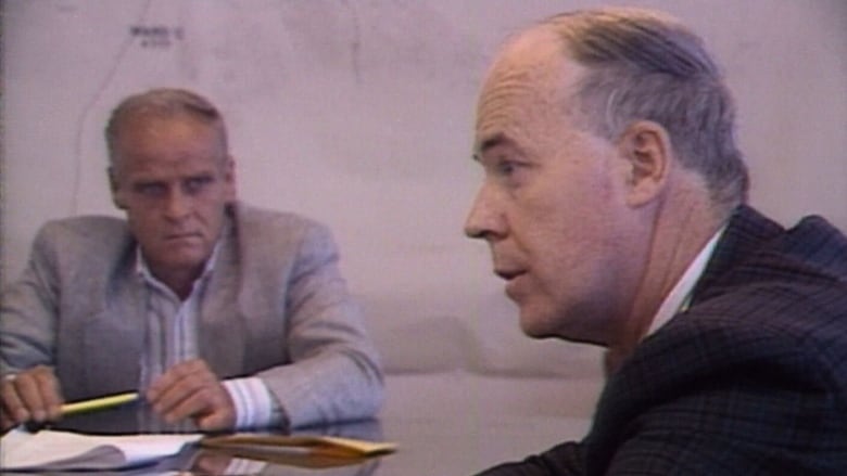 Two men sit near each other at a table.