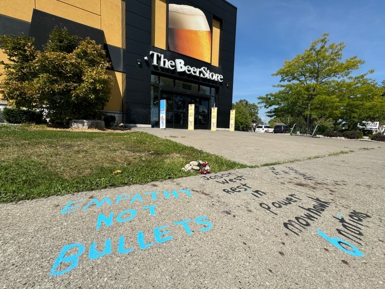 Text on sidewalk, small memorial in front of Beer Store