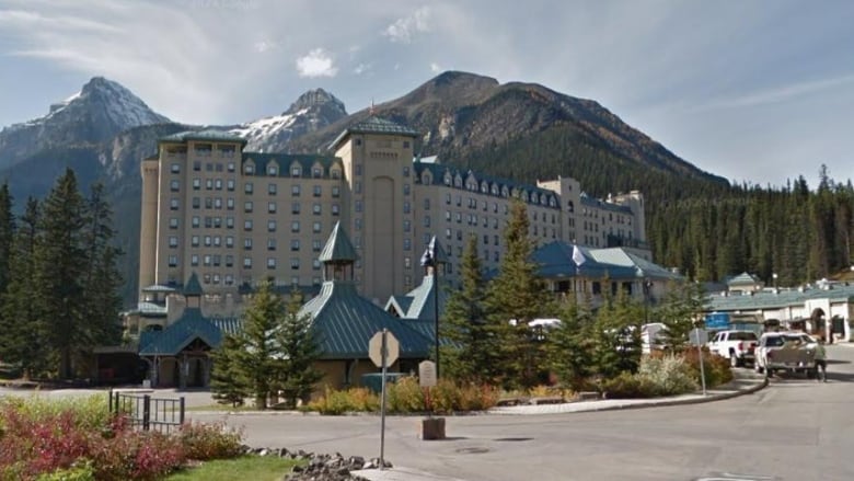 A large hotel complex is seen with a mountain behind it.