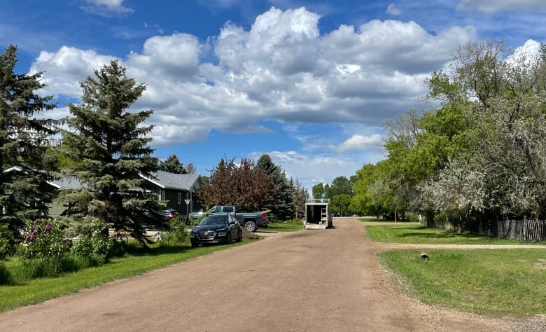 A dirt road in a small suburb. 