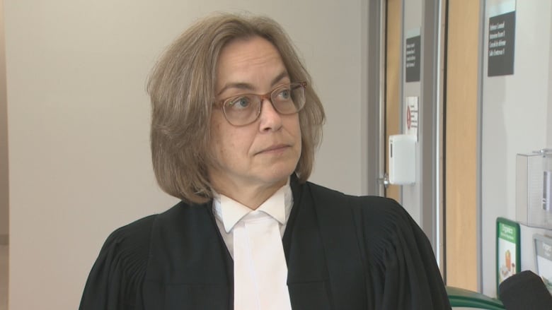 A Crown Prosecutor wearing court robes is looking off-side.