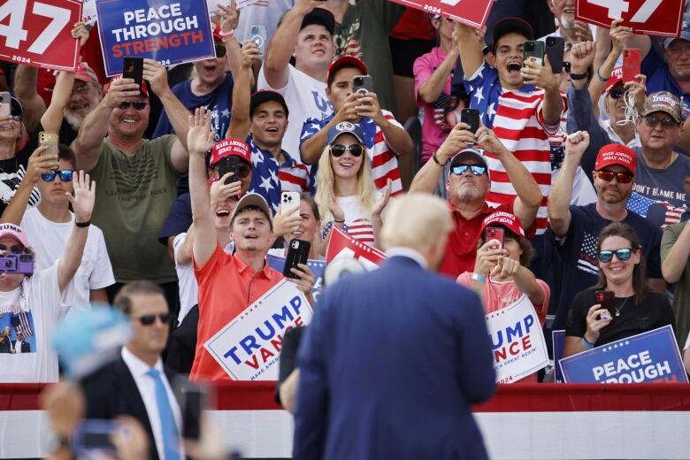 Trump, seen from behind, speaking to crowd.