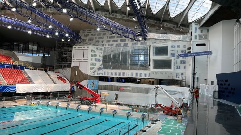 A large swimming area with workers nearby. 