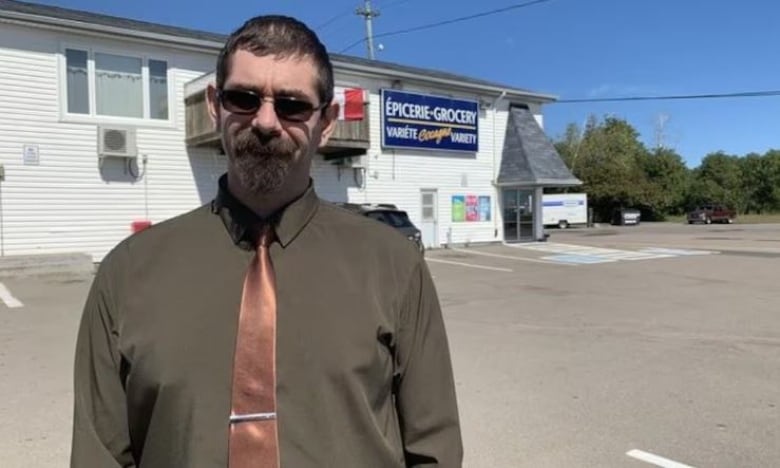 Benoit Poirier stands up outside of a building.