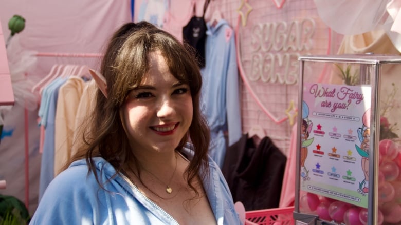 A portrait of a person with elf ears in a pink booth