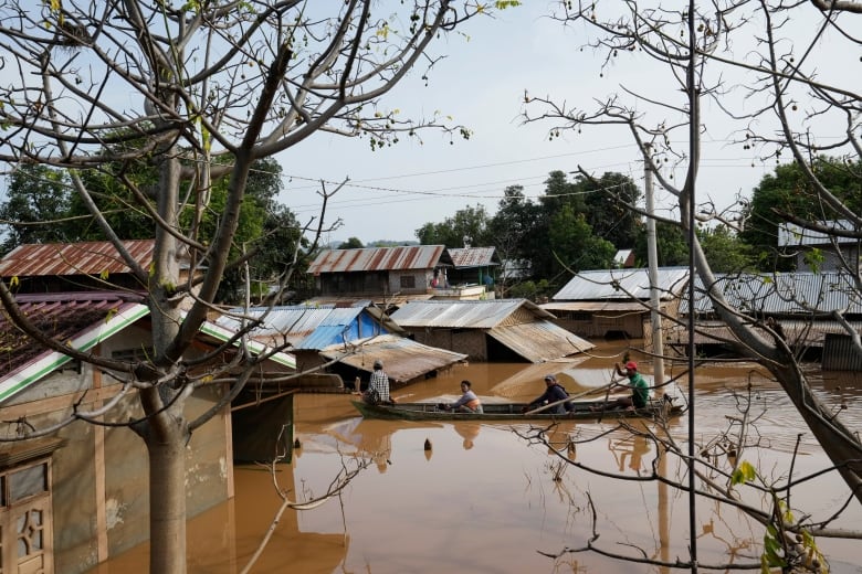 People travel by boat on a flooded road.