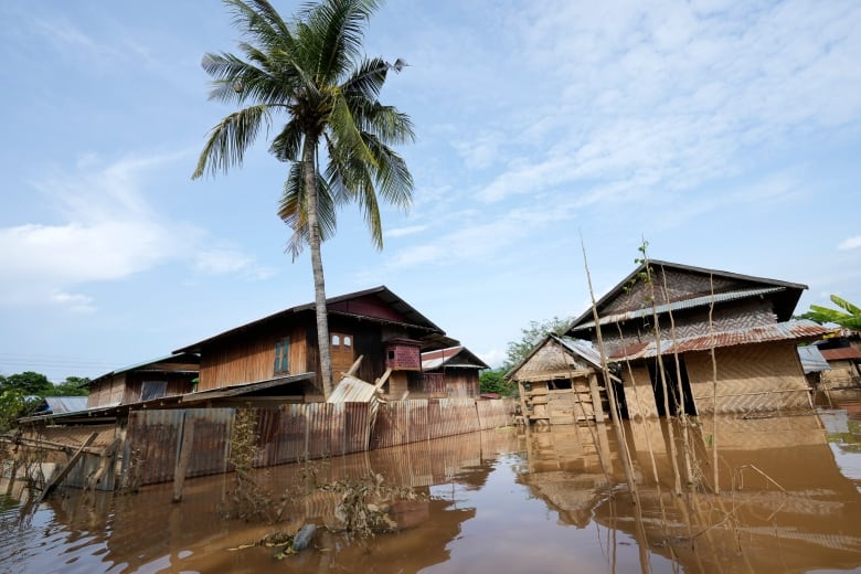 Partially submerged buildings along a flooded road. 