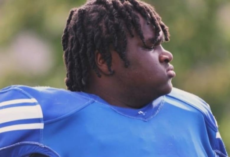 A youth football player in a blue jersey.