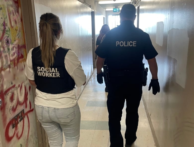 Social worker and Windsor police officer walking down a hallway.