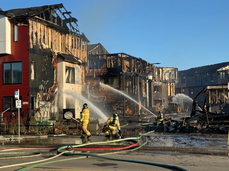 Firefighters hose down a townhouse.