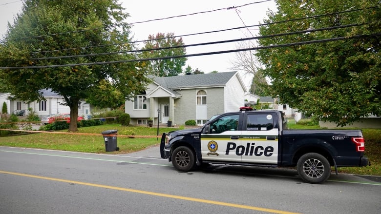 A police car in front of a home. 