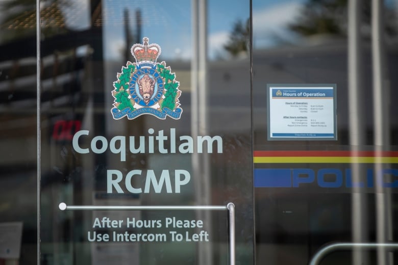 A sign outside a police detachment reads 'Coquitlam RCMP After Hours Please Use Intercom To Left.'