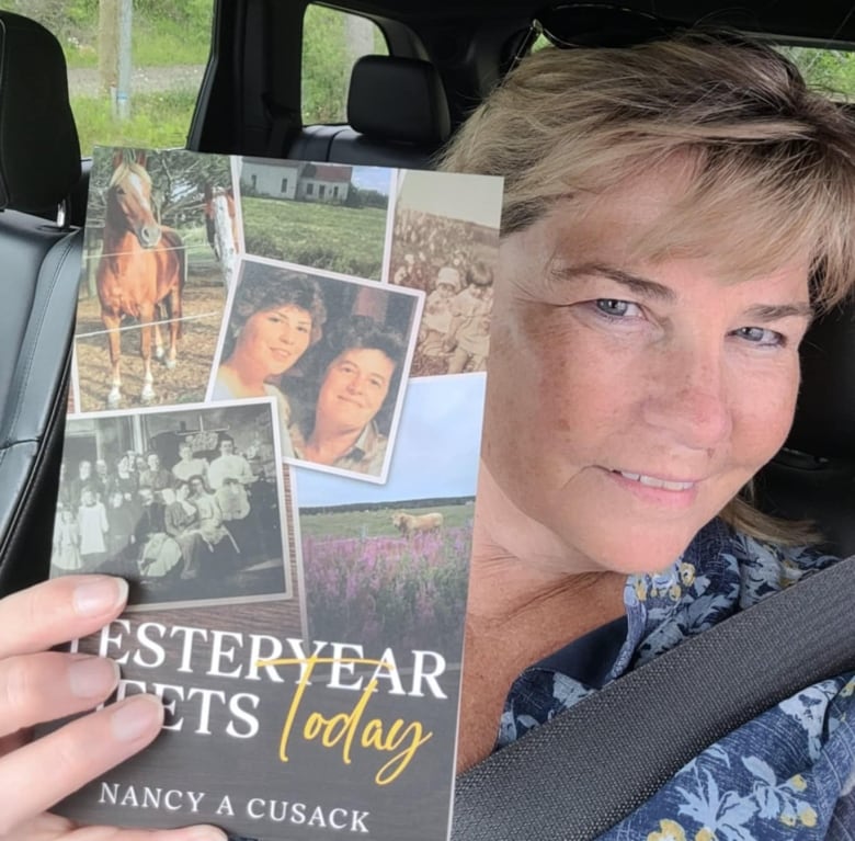 A smiling woman posing with a book