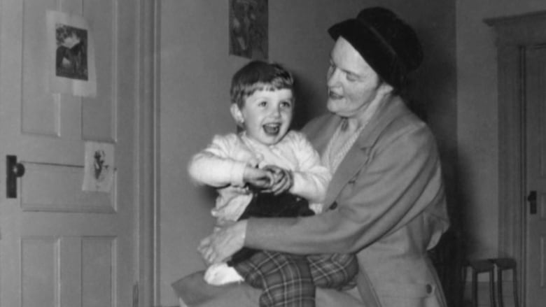 A black and white image of a woman holding a child.