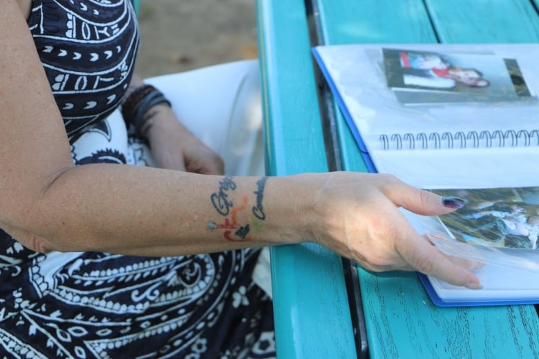 A woman's arm showing a tattoo of her son's name. 