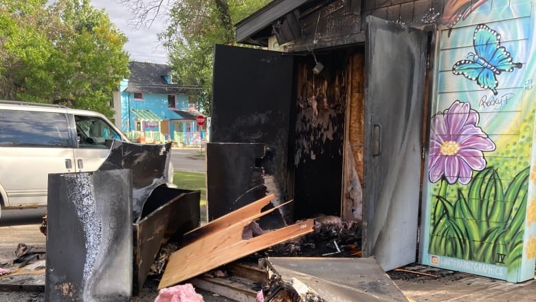 A community fridge structure is charred and burned