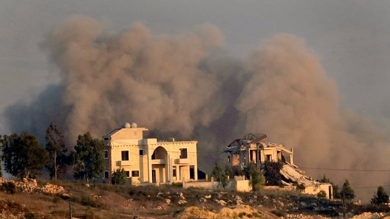 Smoke rises behind a destroyed house following an Israeli airstrike on Khiam village, as seen from Marjayoun town, south Lebanon, Tuesday, Sept. 24, 2024.