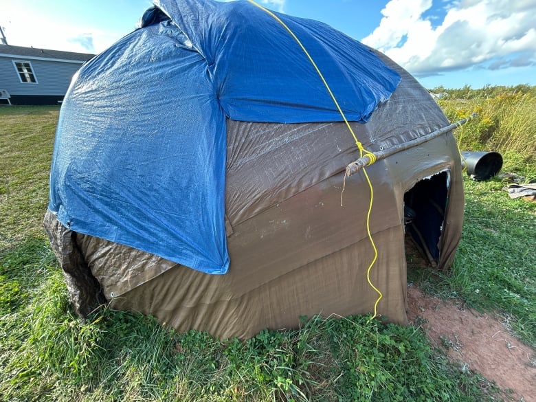 Structure covered in blue and grey tarp.