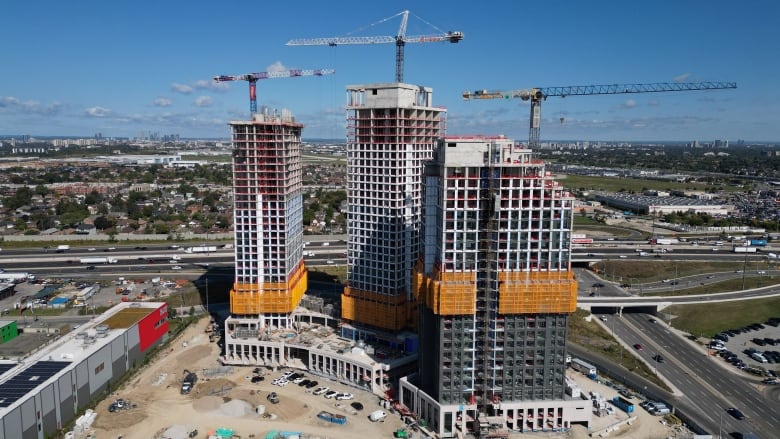 Cranes are set up as three condo buildings are under construction