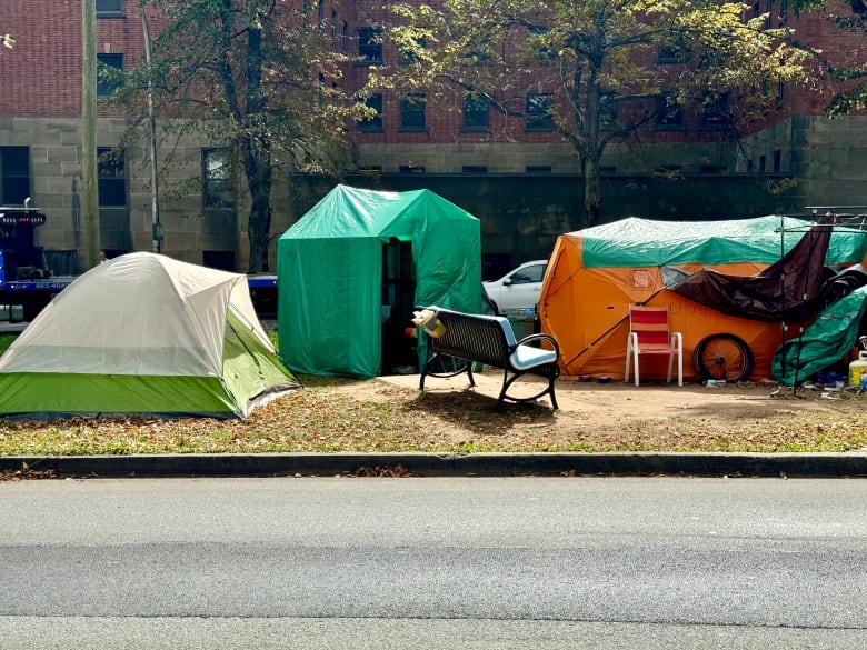 A group of tents in a row with a bench in front of them