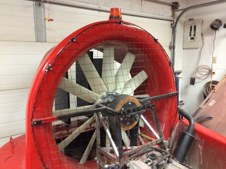 A large propeller encased by a bright red frame. 