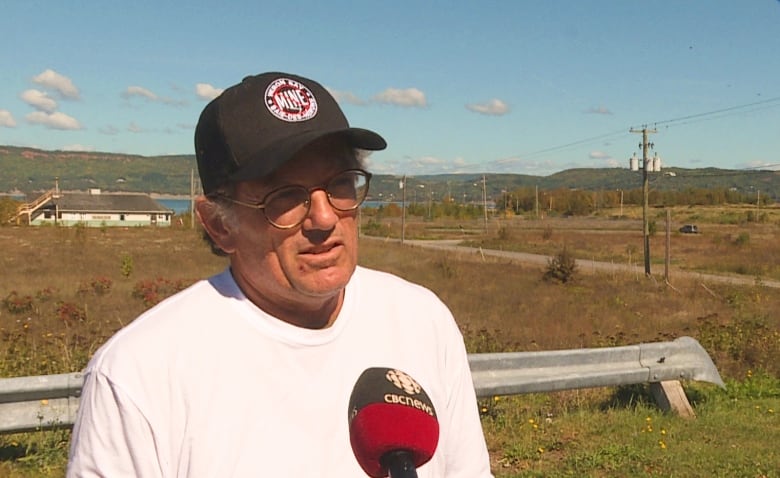 A man in a white shirt and wearing a black hat with a a 