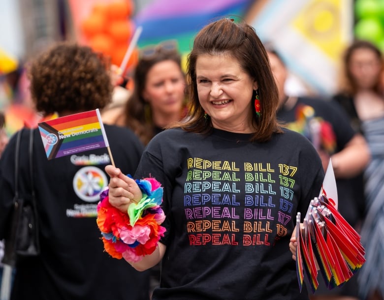 Sask. NDP Leader Carla Beck holds pride flags during a pride parade in Regina in June. She has vowed to repeal Bill 137 if elected.