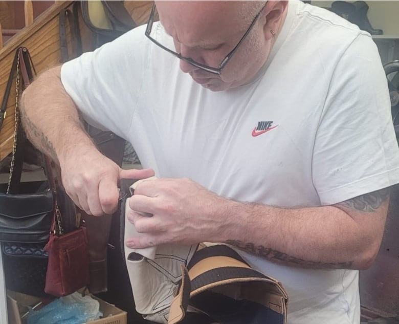 A man works on a shoe in his workshop.