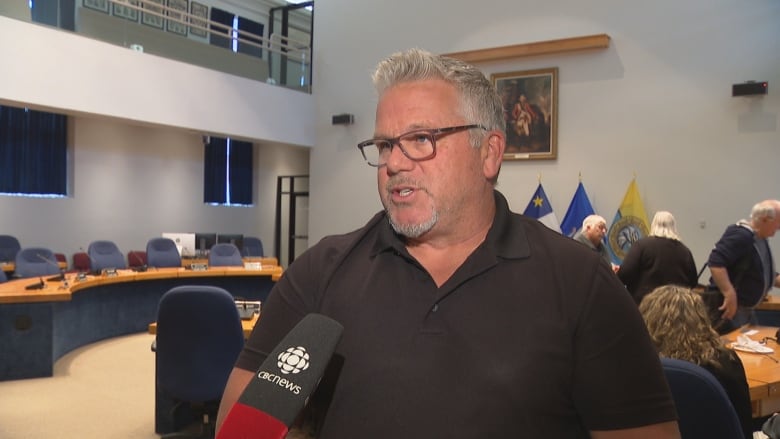 Steve Hicks speaks into a microphone in Fredericton council chambers.