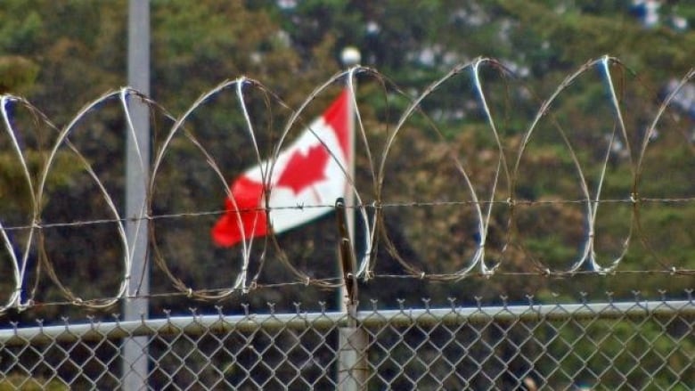 Barbed wire and a Canadian flag.