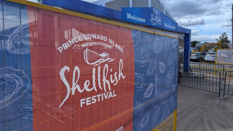 A sign reading PEI International Shellfish Festival outside of an entrance gate.