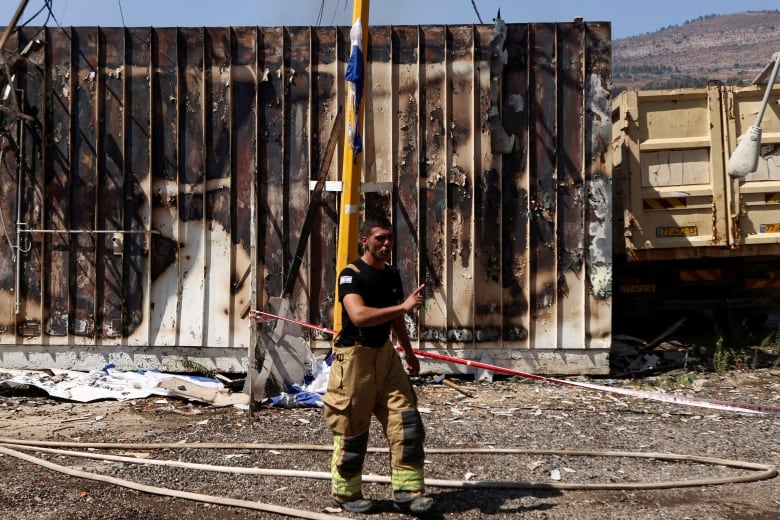 A firefighter stands at the site of a damaged city government building in Kiryat Shmona following a rocket attack from Lebanon, amid cross-border hostilities between Hezbollah and Israel, in northern Israel, September 24, 2024.