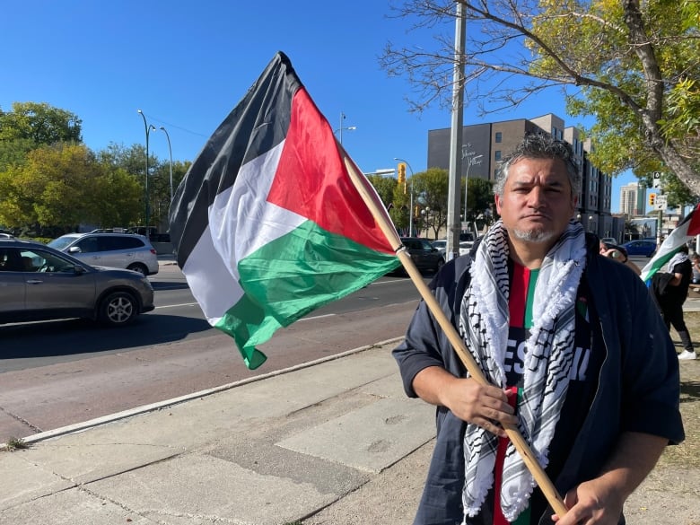 A man holds a Palestinian flag. 