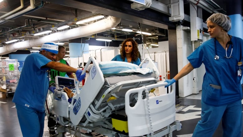 Medical staff move a patient