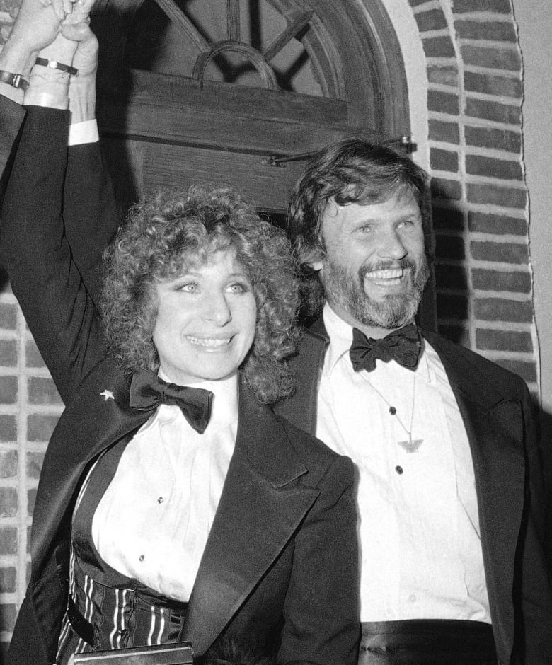 Two people smile and raise their arms in this black and white photo.