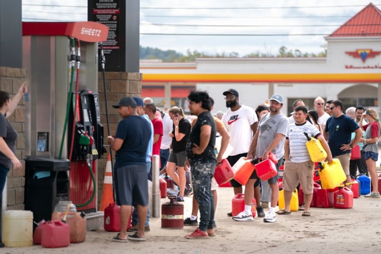 People line up to buy gasoline.