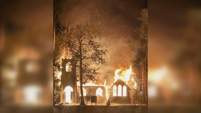 Church burning in flames in the nightime.