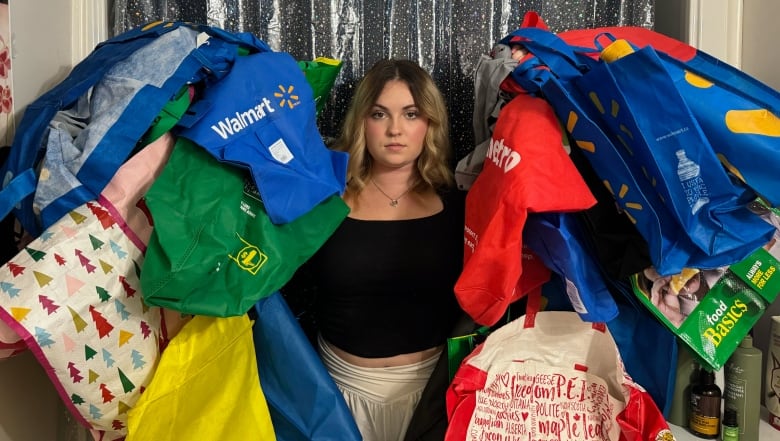 Megan Bishop surrounded by dozens of reusable bags. 