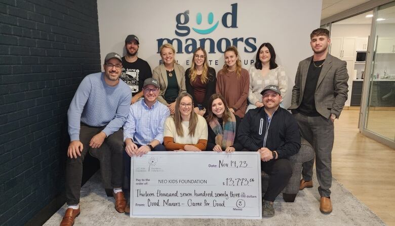 People standing around a giant cheque.