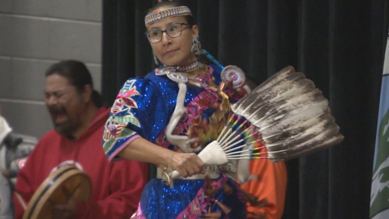 A woman dancing in colourful indigenous outfit. 