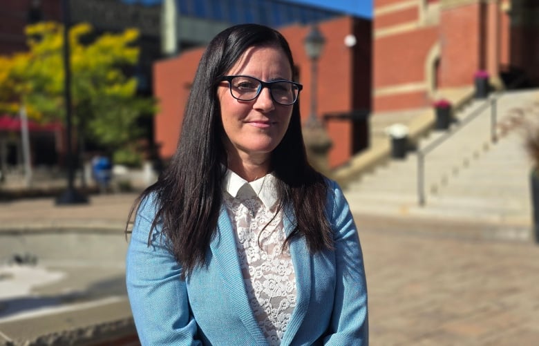 A woman with black hair and a blue blazer.